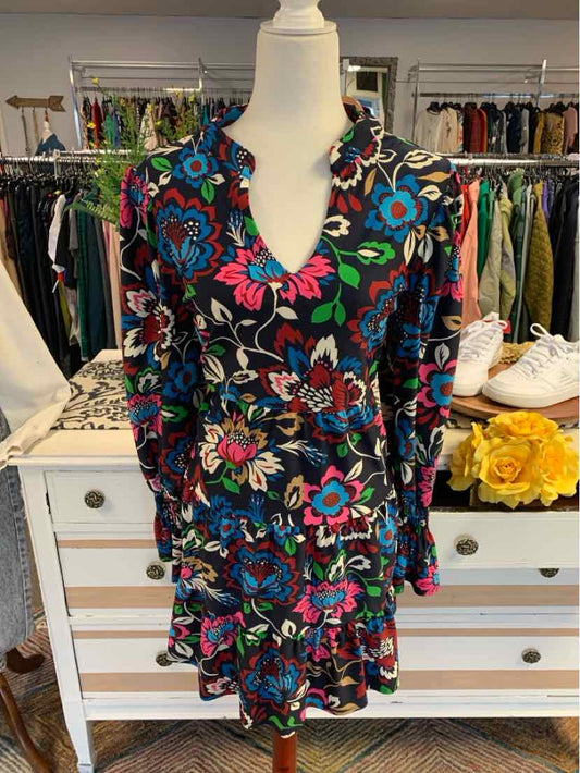 Floral print long-sleeve dress with v-neck and ruffled hem in blue, pink, and green tones.