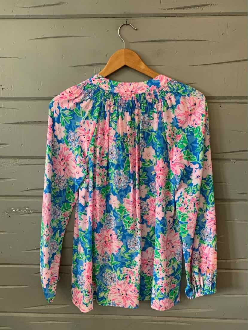 Long-sleeve blouse with pink and blue floral print on a white background, lightweight fabric.