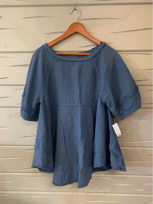 Blue loose-fit casual top with elbow-length sleeves hanging on wooden hanger.