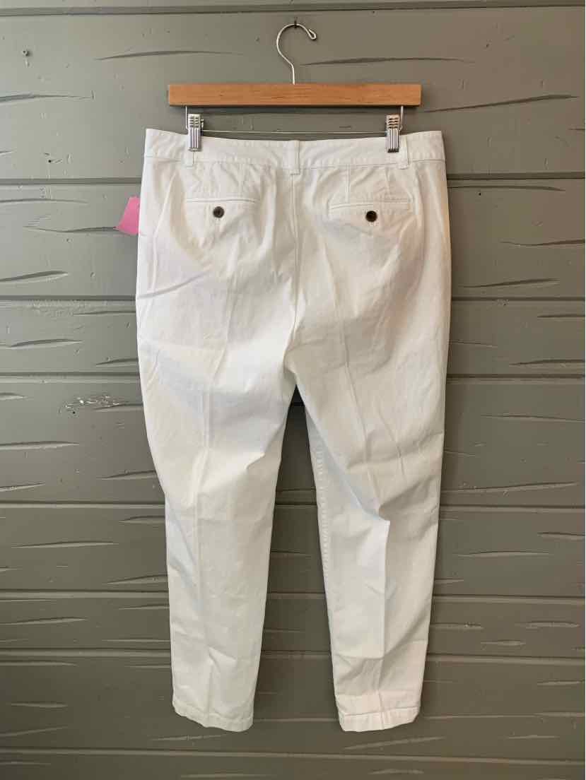 White mid-rise pants with buttoned back pockets and straight legs on wooden hanger.
