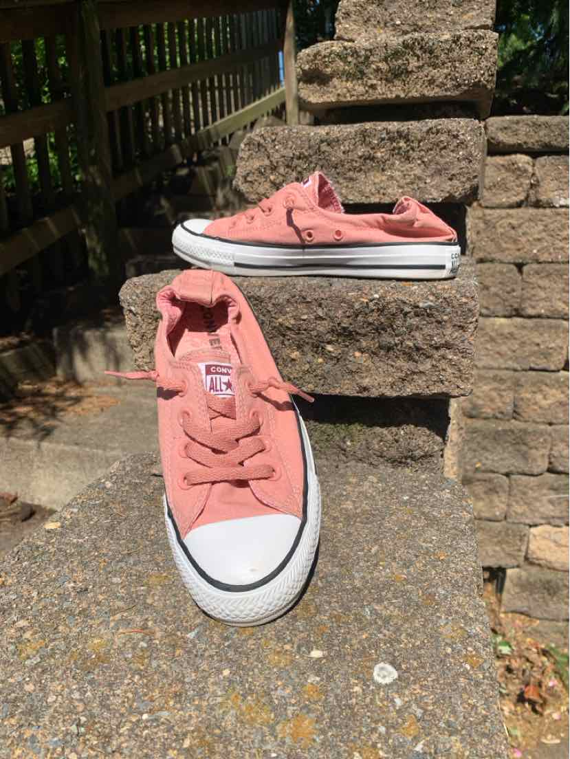 Pink low-top Converse sneakers with white rubber toe caps and soles, size 7.5.