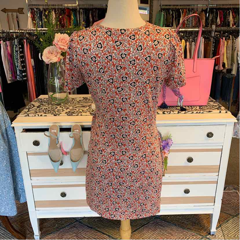 Tan floral short-sleeve fitted dress with small black and white flower patterns.