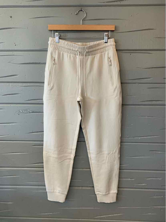 Cream Old Navy pants with an elastic drawstring waist, side pockets, and tapered legs.