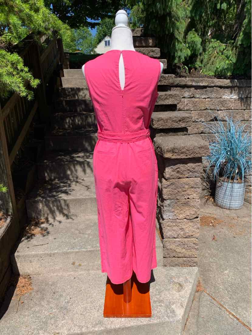 Sleeveless pink jumpsuit with keyhole back and wide-leg cropped pants on mannequin outdoors.