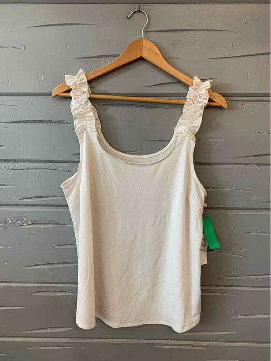 White sleeveless top with ruffled straps hanging on wooden hanger against gray wooden background.