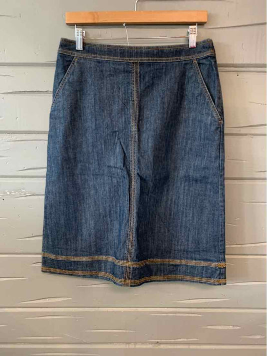 Denim knee-length skirt in dark blue with contrast orange stitching and front pockets.
