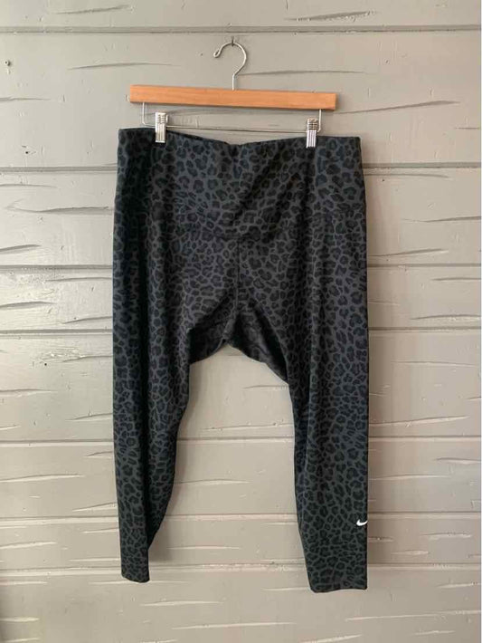 Black Nike leggings with subtle cheetah print and small white Nike swoosh on lower leg.
