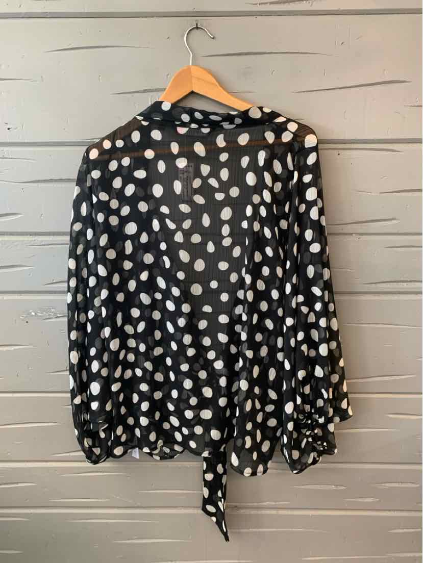 Black sheer blouse with white polka dots, long sleeves, and a tie detail at the hem.