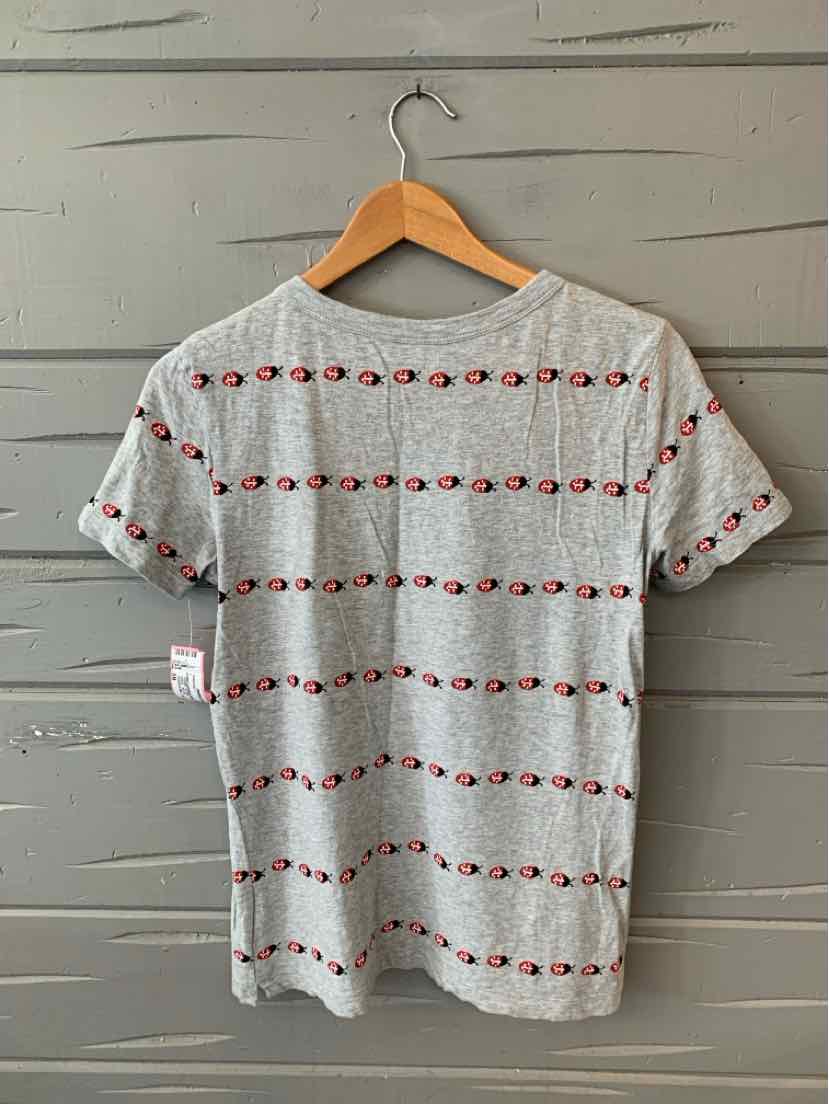 Gray short-sleeve t-shirt with horizontal rows of small red and black ladybug patterns hanging on wooden hanger.