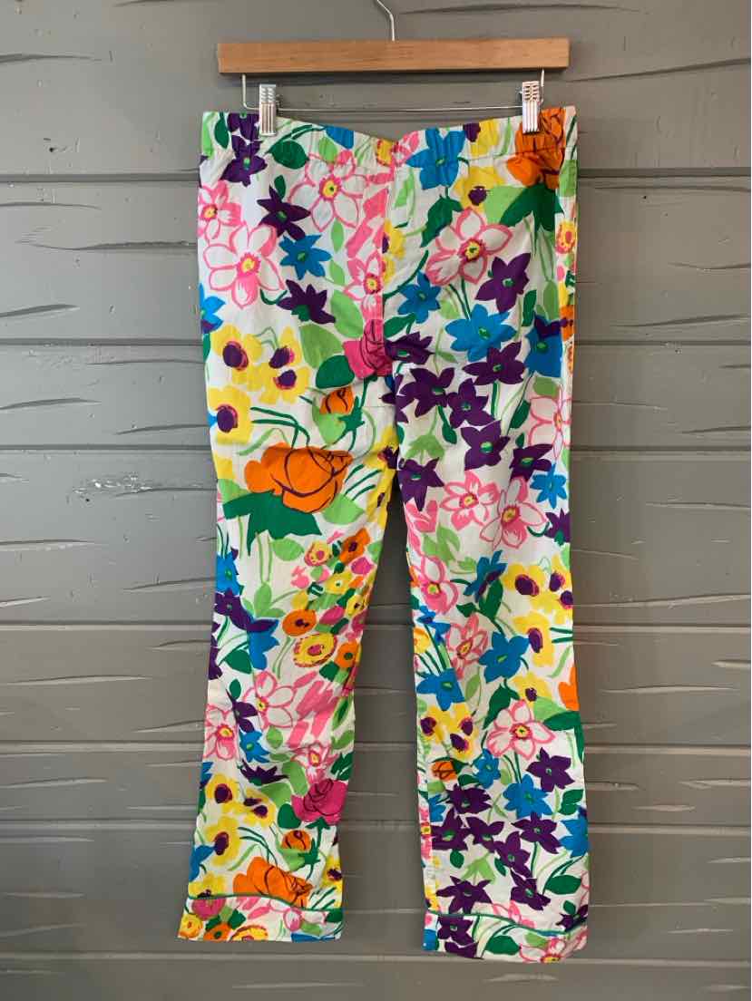Floral-print slim-fit pants with vibrant multicolor flowers on white background.
