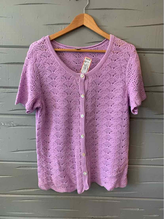 Lavender knit cardigan with short sleeves, scalloped edges, and pearly buttons down the front.