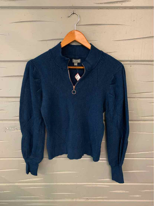 Navy blue long-sleeve sweater with zip front and ribbed cuffs on wooden hanger.