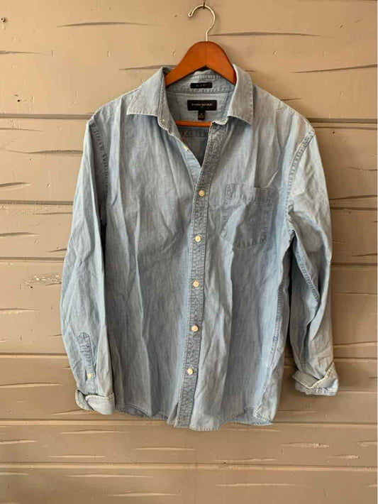 Light blue long-sleeve button-up shirt with collar, single chest pocket, and slightly wrinkled cotton fabric.