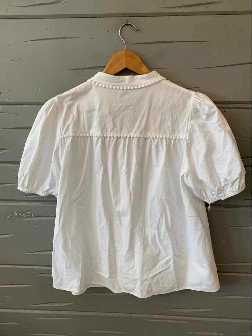 White short-sleeve blouse with puffed sleeves and delicate lace trim at the collar, lightweight fabric.