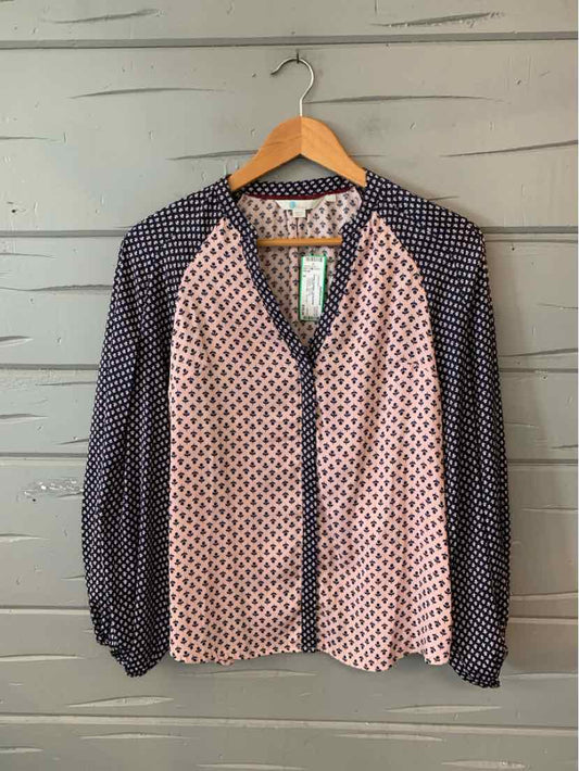 Pink and navy floral blouse with navy polka dot sleeves and button-down front.