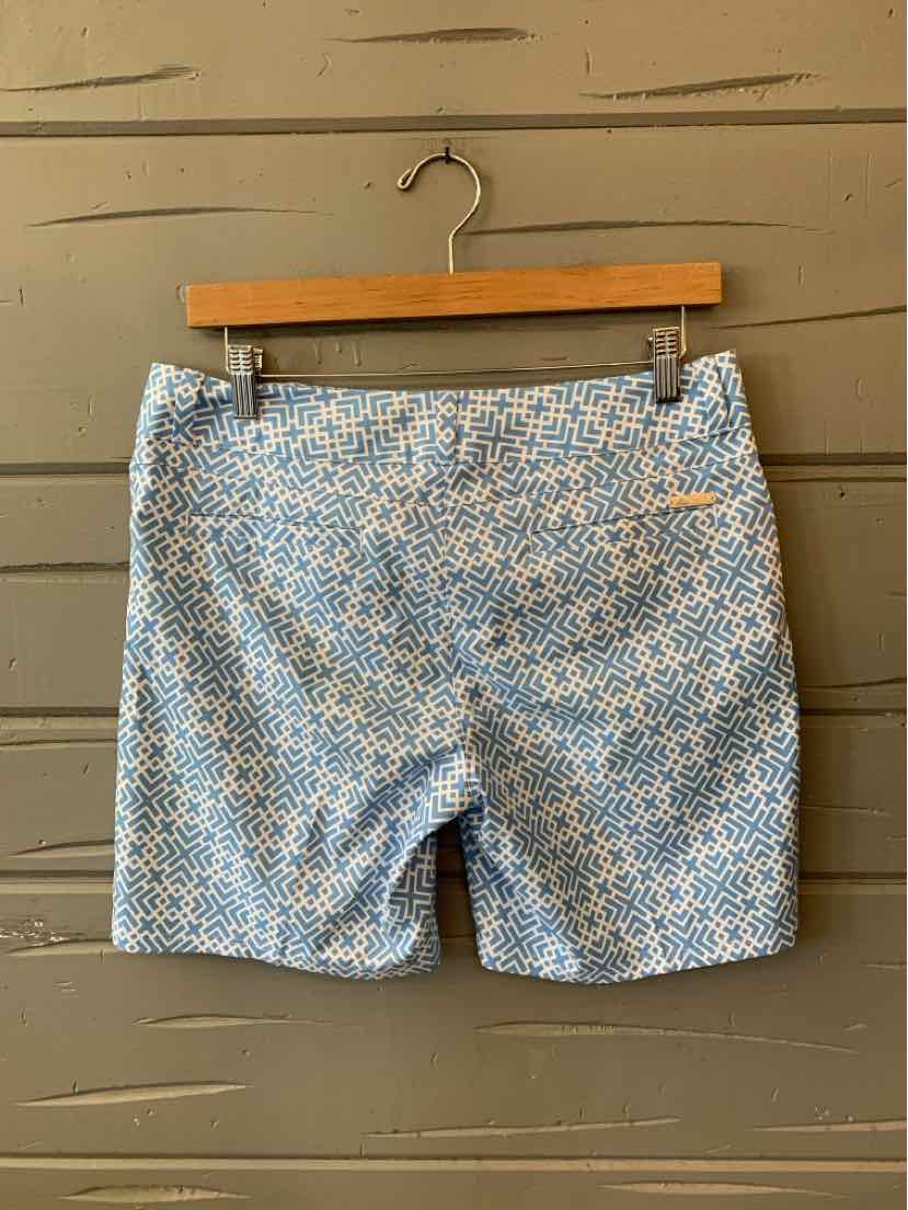 Light blue and white patterned athletic shorts with waistband and back pocket, hanging on wooden hanger.