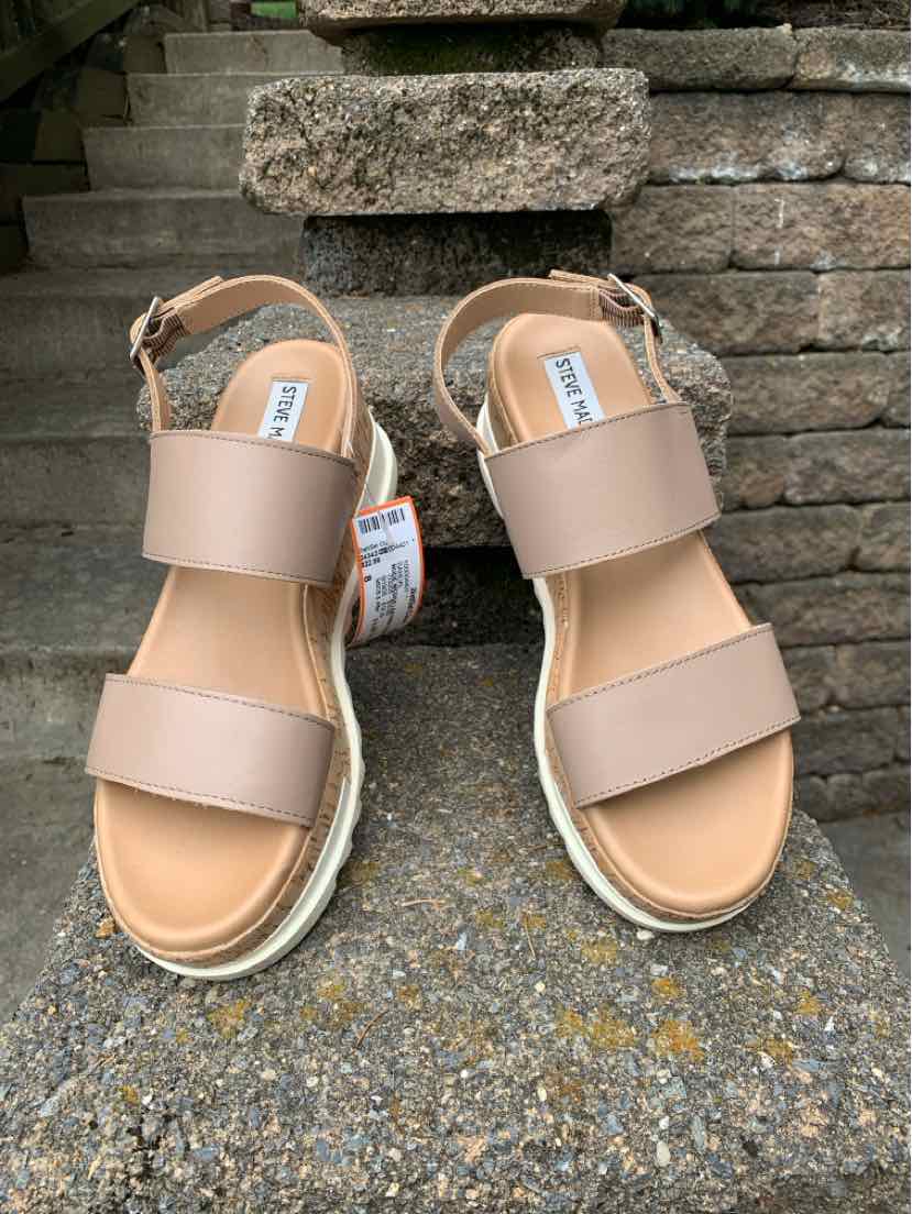 Nude leather sandals with two wide straps and ankle buckle on woven espadrille platform.
