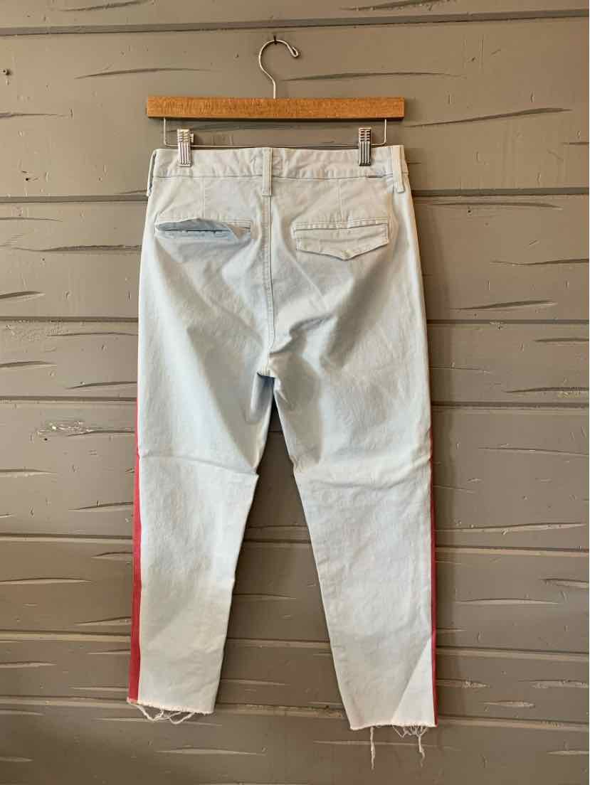 Light blue denim jeans with red side stripes and two back pockets hanging on a wooden hanger.