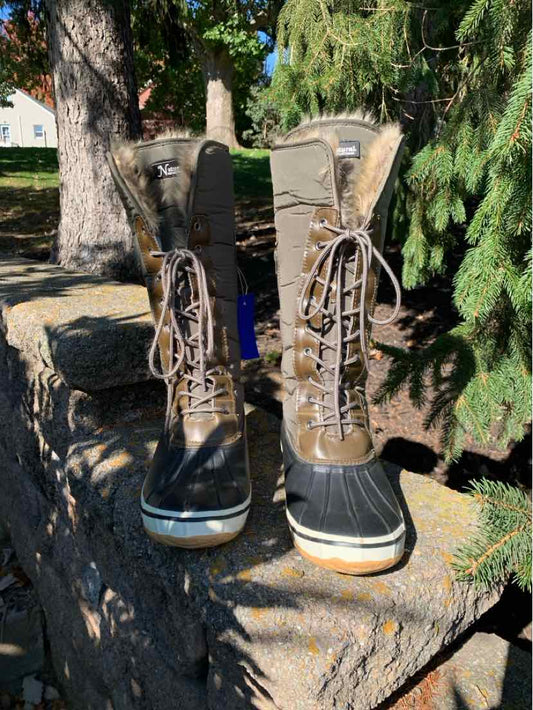 Pair of tan and brown lace-up women’s boots with black padded collars, eyelets, and thick dark soles.