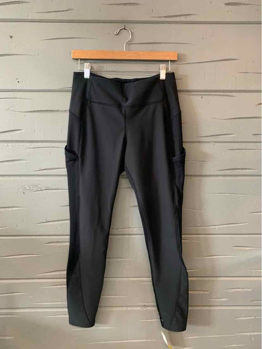 Black high-waisted athletic leggings with side pockets and a smooth, stretchy fabric finish.