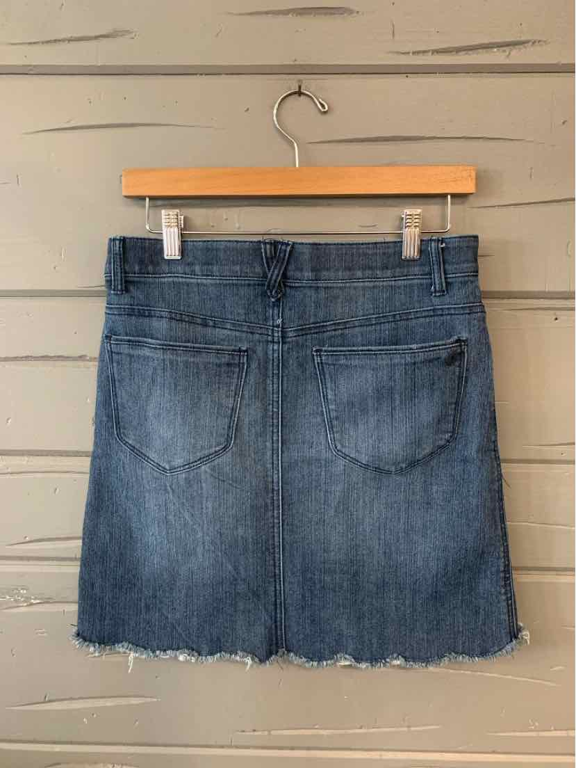 Blue denim mini skirt with frayed hem and two back pockets on wooden hanger.
