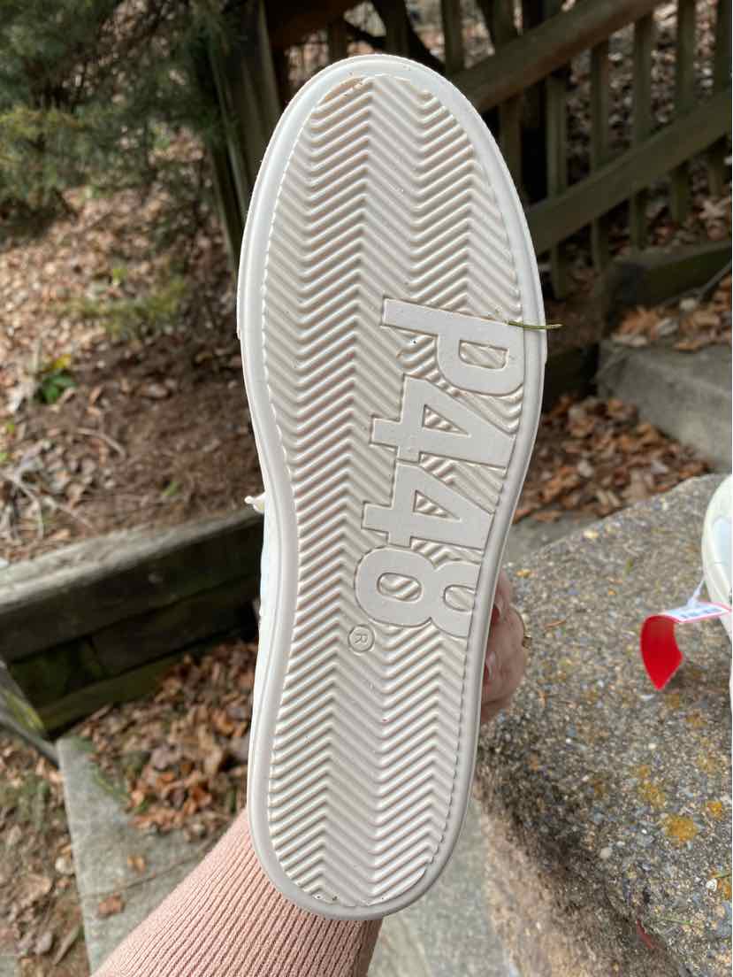 White sneaker sole with herringbone tread pattern and embossed "P448" logo.