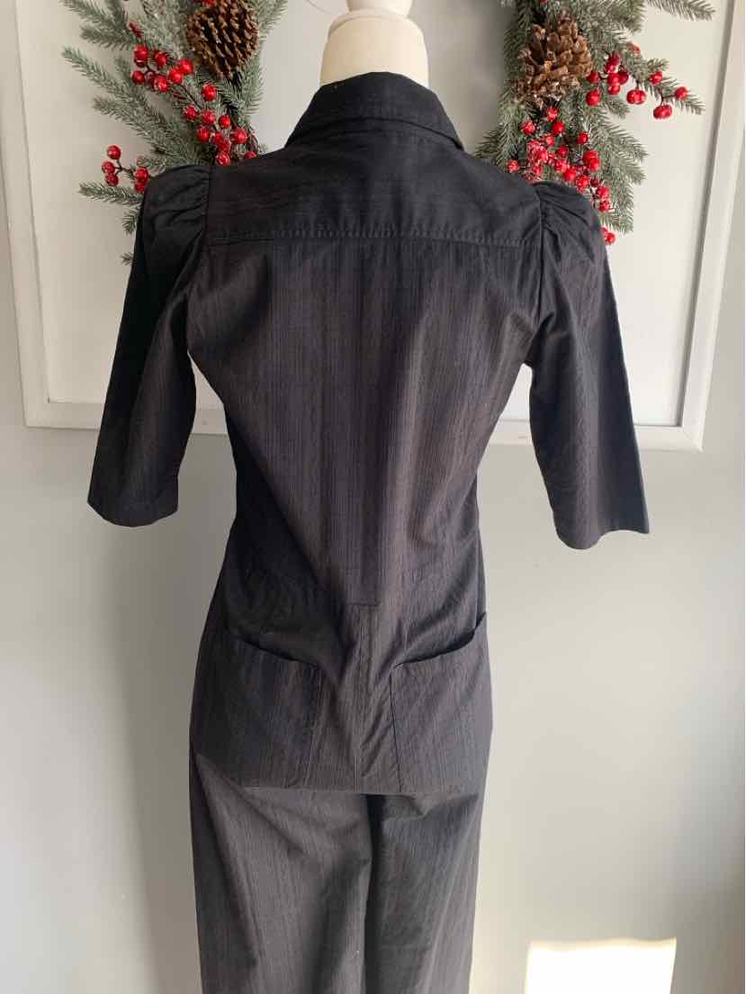 Black fitted blazer with three-quarter puff sleeves and tailored waist detail.