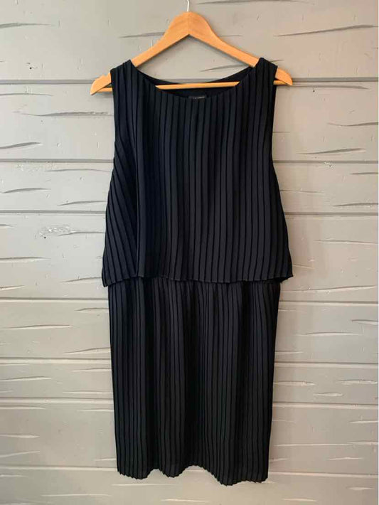 Black sleeveless midi dress with vertical pleats and round neckline on wooden hanger.