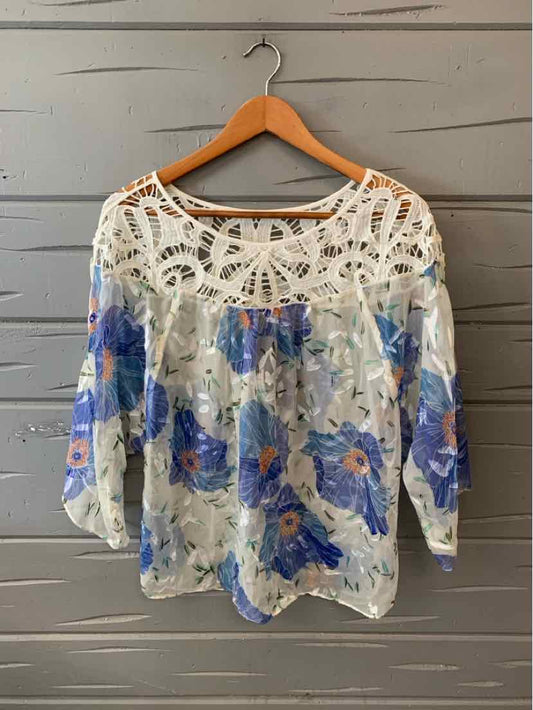 White blouse with blue floral print, sheer fabric, and intricate crochet lace yoke and shoulders, size 10.