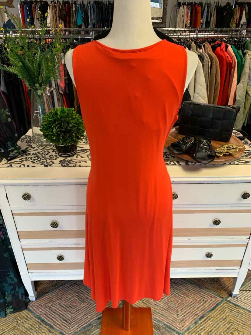Sleeveless solid orange knee-length dress with round neckline on mannequin.