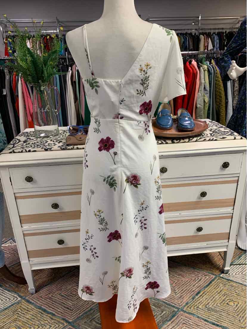 White midi dress with thin straps and floral print in red, purple, and green colors.