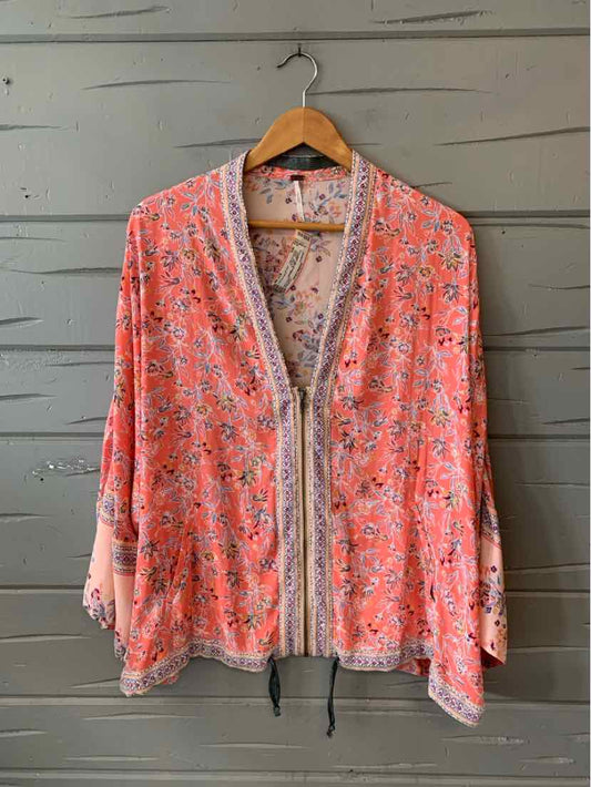 Pink floral lightweight cardigan with long sleeves and front zipper on wooden hanger.