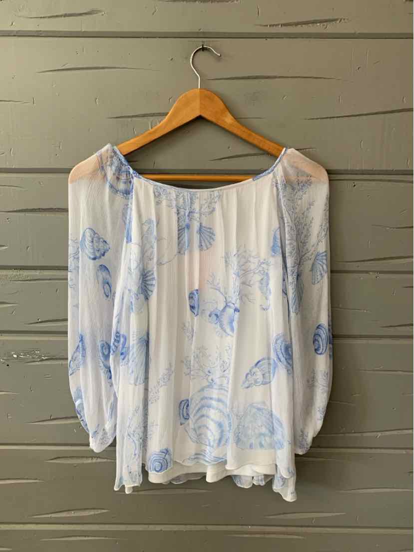 White sheer blouse with blue seashell print, loose fit, long puffed sleeves, elastic neckline and cuffs.