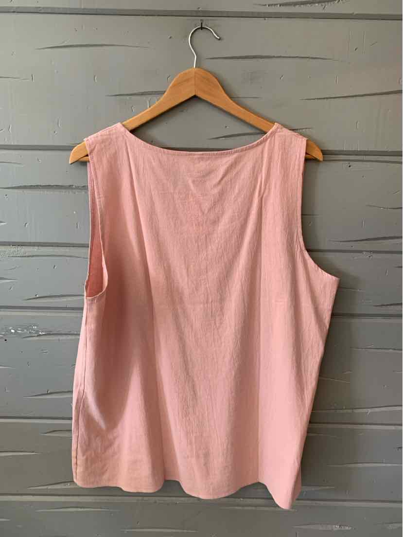 Light pink sleeveless tank top with a loose fit, round neckline, and smooth fabric hanging on wooden hanger.