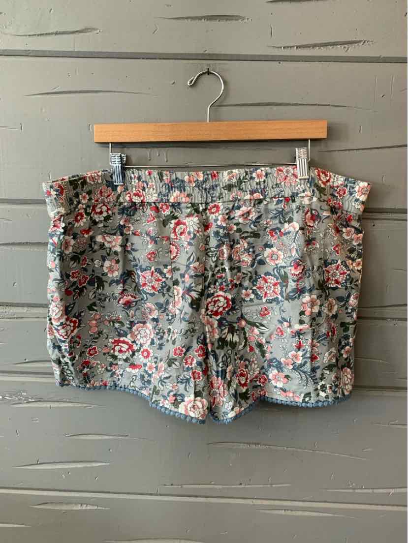 Floral print cotton shorts in blue, pink, and white with folded hems and button closure.