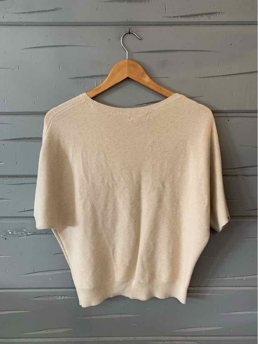 Tan lightweight knit top with loose short sleeves and a boat neckline on wooden hanger.