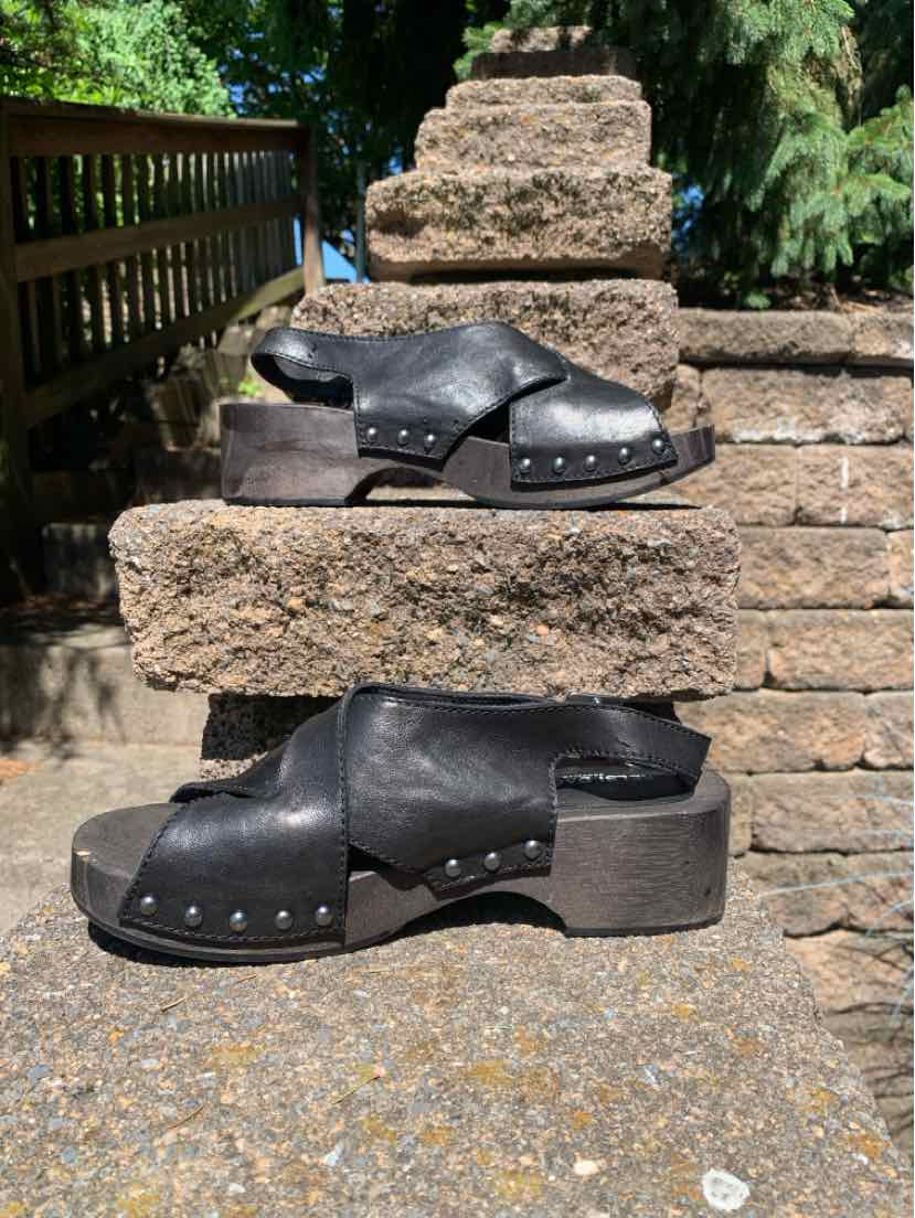 Black leather open-toe sandals with wide straps, metal studs, and chunky low heels, size 7.5.