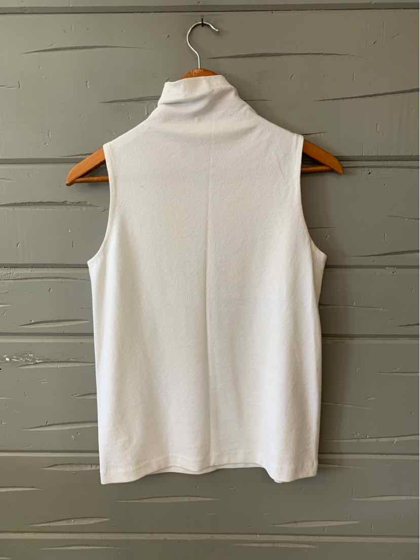 White sleeveless turtleneck top with slim fit on wooden hanger against gray wall.
