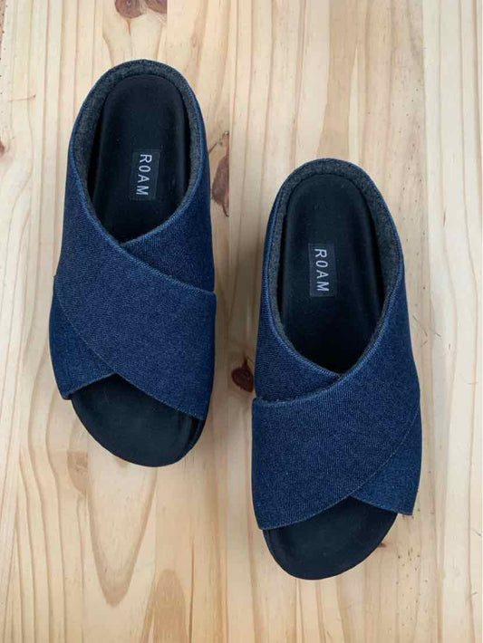 Navy blue slip-on sandals with crisscross fabric straps and black cushioned soles, size 9.