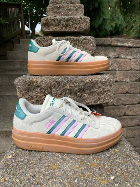 Women's Adidas sneaker in light gray with pastel purple and teal stripes, thick gum sole, and suede accents.