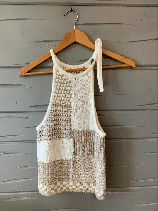White and beige knit sleeveless top with mixed textured patterns and tie shoulder straps.