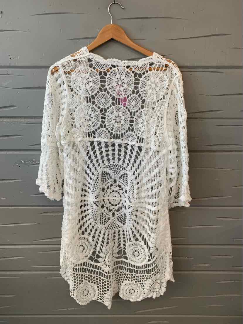 White crochet knit cover-up with floral and geometric patterns, mid-length sleeves, and scalloped hem.