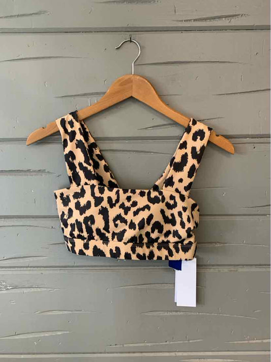 Tan cheetah print cropped tank top with wide straps hanging on wooden hanger.