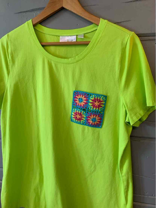 Bright lime green short-sleeve T-shirt with round neckline and colorful crocheted square pocket on left chest.
