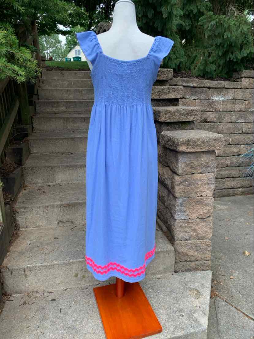 Light blue sleeveless dress with ruffled straps, smocked bodice, and bright pink decorative trim along the hem.
