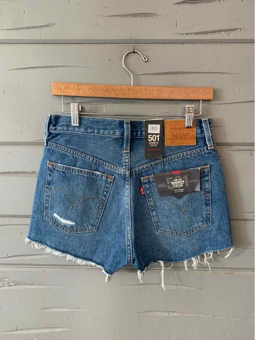 Blue denim Levi's cutoff shorts with frayed hem and back pockets, size 2.