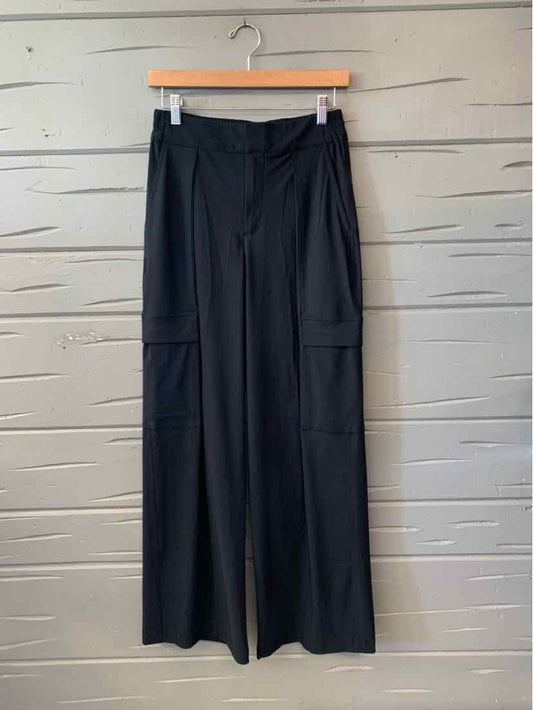 Black Athleta wide-leg pants with a high waist, front pleats, and large cargo pockets.