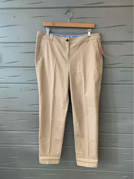 Khaki tailored women's trousers with belt loops and front pockets on wooden hanger.