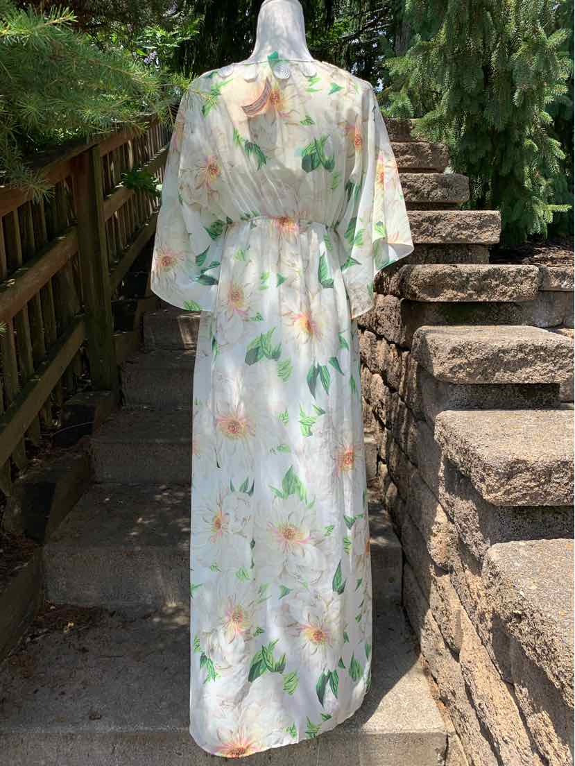 Maxi dress with white base and multicolored floral print, sheer lightweight fabric, loose fit with cinched waist and.