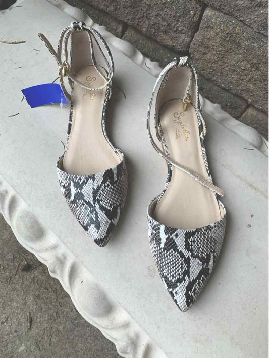 Black and white snakeskin pointed toe flats with ankle wrap straps in size 8.5.